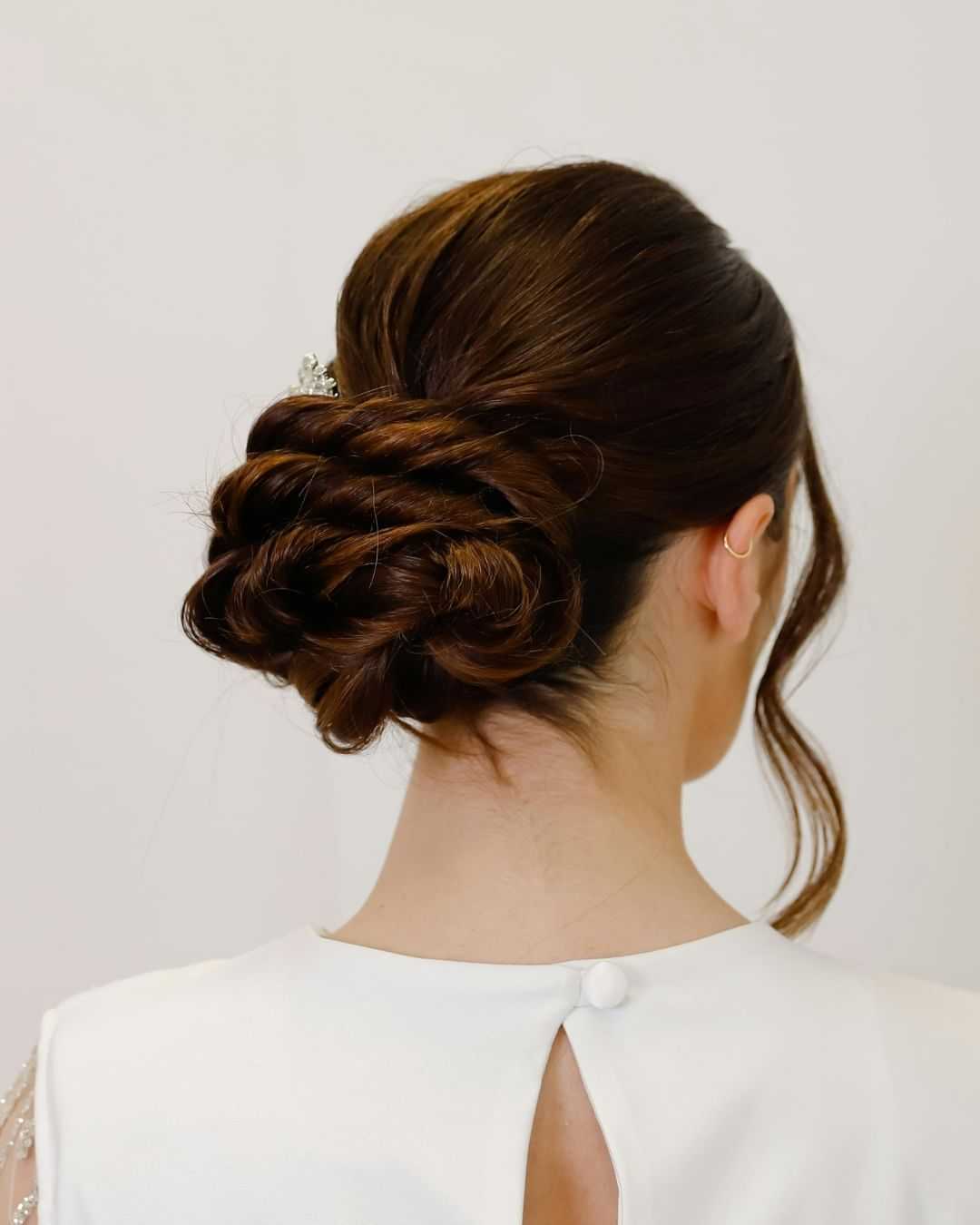 Elegant bridal hairstyle with intricate braided bun and delicate hair accessory.