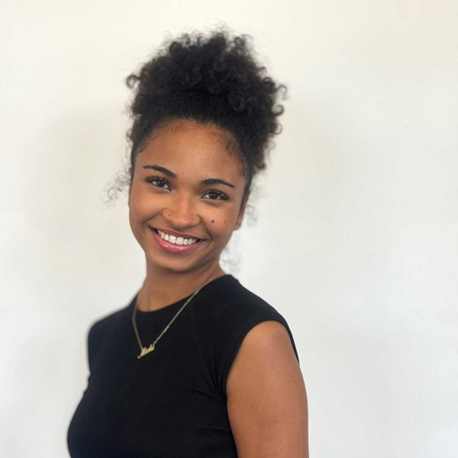 Portrait of Michi, a professional stylist at ARIA Salon, showcasing their expertise and style.